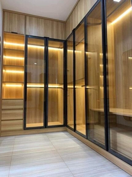 Luxury wood-finished wardrobe with glass doors and integrated LED lighting.